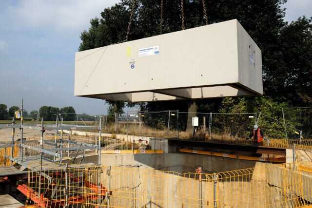 Ablassen der Doppelkammer-Fertigteile mit rd. 44 t Einzelgewicht in die Schlitzwandbaugrube. Das Fertigteilwerk hatte in Anlehnung an das Konzept der Düker-Vortriebsrohre eine SW-Beton-Rezeptur erarbeitet. Ablassen der Doppelkammer-Fertigteile mit rd. 44 t Einzelgewicht in die Schlitzwandbaugrube. Das Fertigteilwerk hatte in Anlehnung an das Konzept der Düker-Vortriebsrohre eine SW-Beton-Rezeptur erarbeitet.