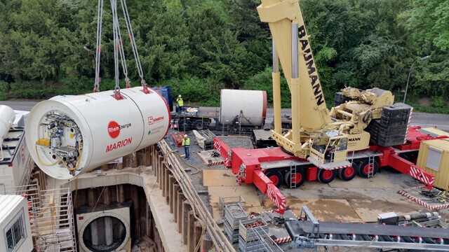 Kein Leichtgewicht selbst für einen 500-t-Kran: die rund 100 t schwere Microtunneling-Vortriebsmaschine beim Einheben in die Startbaugrube Kein Leichtgewicht selbst für einen 500-t-Kran: die rund 100 t schwere Microtunneling-Vortriebsmaschine beim Einheben in die Startbaugrube