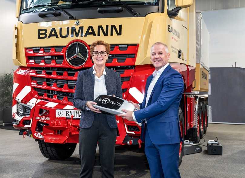 Mercedes-Vertriebsleiter Ronald Ott überreicht Sabine Baumann-Duvenbeck in Wörth einen symbolischen Fahrzeugschlüssel. | Foto: Daimler Truck AG Mercedes-Vertriebsleiter Ronald Ott überreicht Sabine Baumann-Duvenbeck in Wörth einen symbolischen Fahrzeugschlüssel. | Foto: Daimler Truck AG