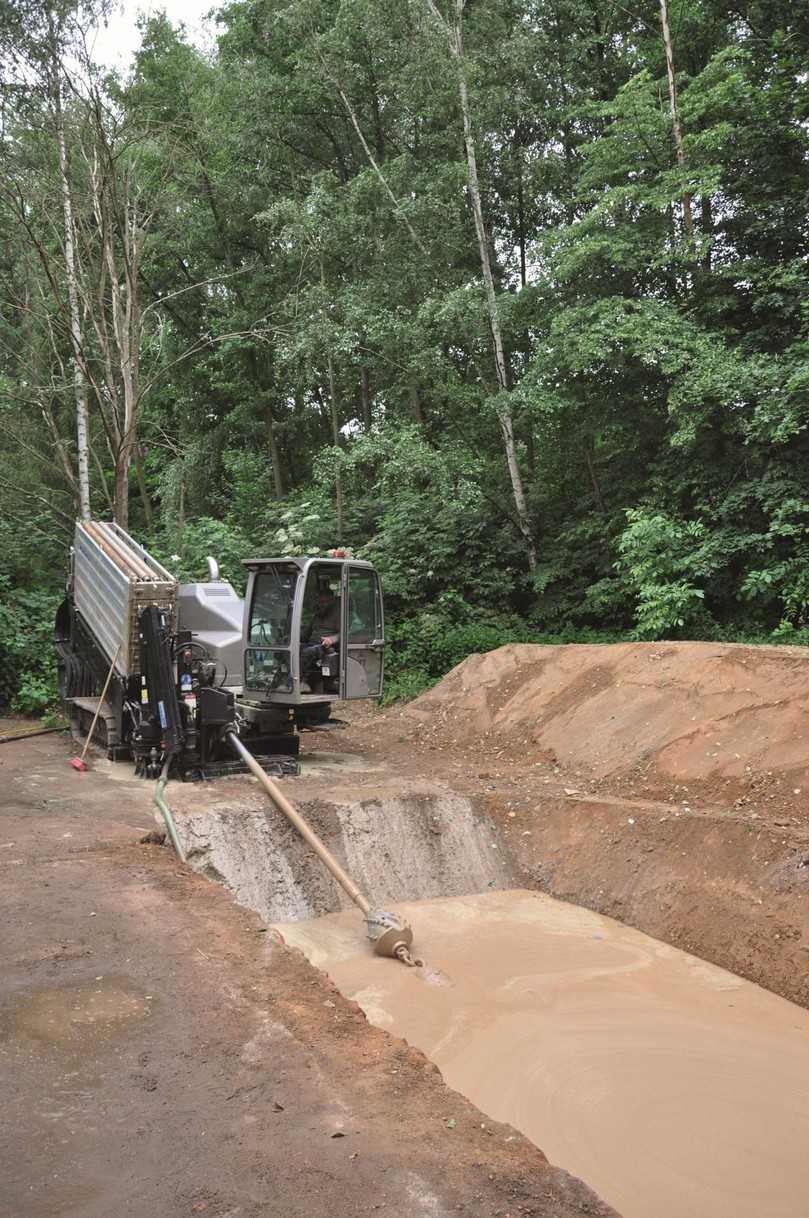 Die fertig verlegte neue Wasserleitung in der Zielgrube am anderen Flussufer. Gut zu sehen sind die verschiedenen Bodenschichten unterschiedlicher Festigkeit. Außerdem wird deutlich, welch geringe Fläche bei grabenlosem Bauen geöffnet werden muss. | Foto: Tracto-Technik Die fertig verlegte neue Wasserleitung in der Zielgrube am anderen Flussufer. Gut zu sehen sind die verschiedenen Bodenschichten unterschiedlicher Festigkeit. Außerdem wird deutlich, welch geringe Fläche bei grabenlosem Bauen geöffnet werden muss. | Foto: Tracto-Technik
