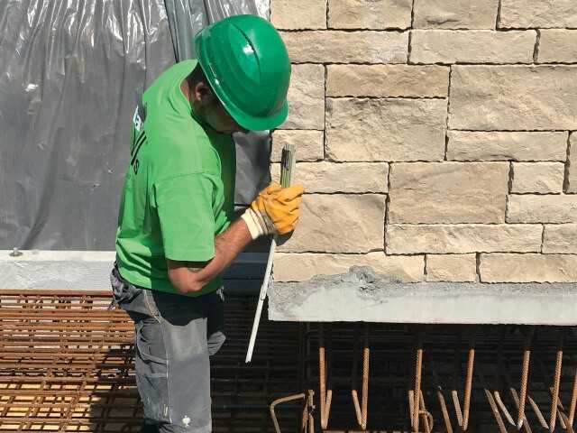 Setzen einer schweren Winkelstützwand. Ist sie fixiert, wird ihre Anschlussbewehrung mit der vorhandenen Armierung im Fertigteilfundament verbunden und mit Ortbeton vergossen. Setzen einer schweren Winkelstützwand. Ist sie fixiert, wird ihre Anschlussbewehrung mit der vorhandenen Armierung im Fertigteilfundament verbunden und mit Ortbeton vergossen.