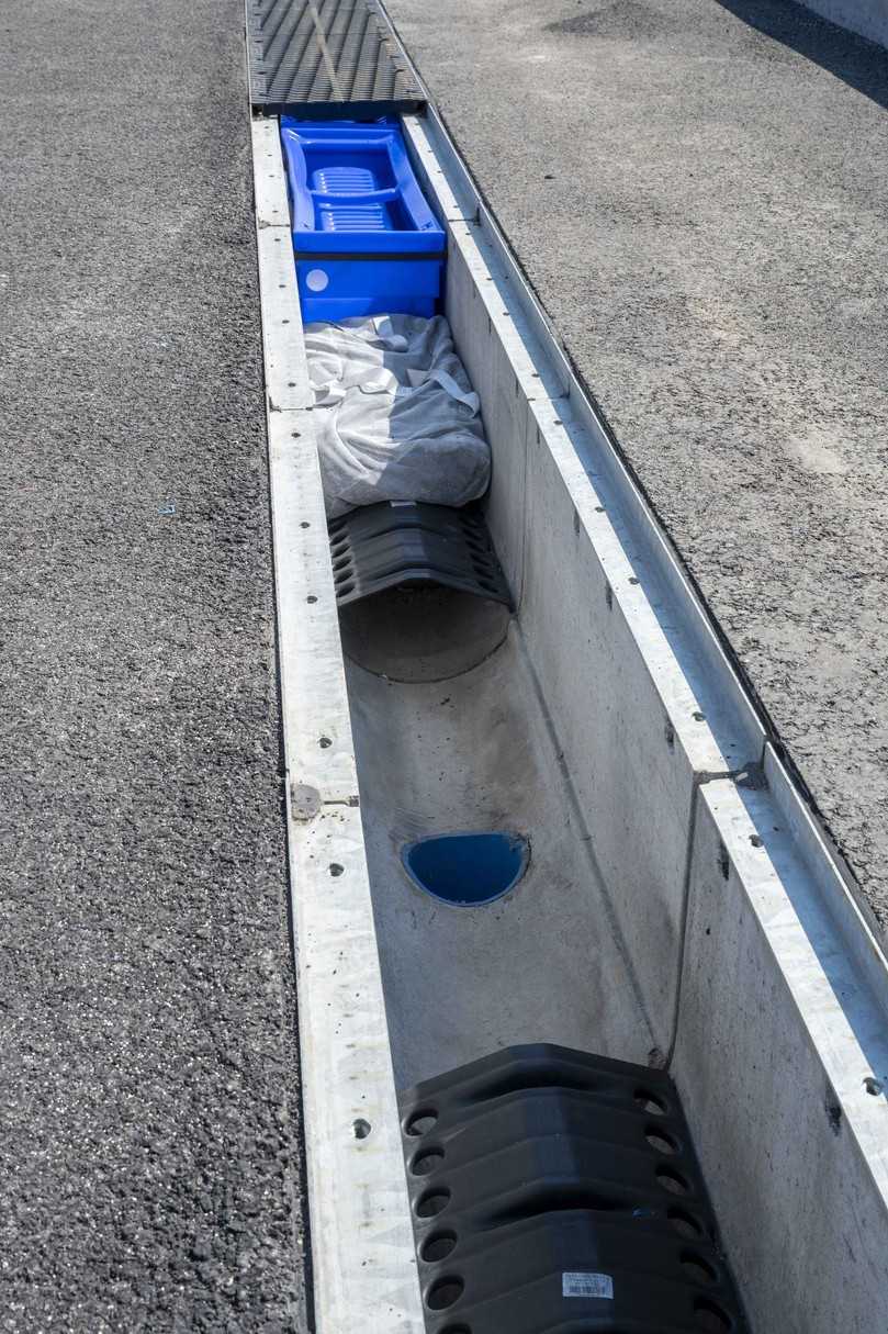Getrennte Module: Die blauen Sedimentationsboxen nehmen zur Grobreinigung alle Feststoffe wie Steine, Laub und Schwebteile auf. Anschließend entziehen die
Granulatfilterkissen dem vorgereinigten Niederschlagswasser organische und anorganische Schadstoffe. Das filtrierte und im freien Abflussraum der Rinne geleitete Regenwasser kann durch Ablaufpunkte in den unterirdischen Rigolen vor Ort versickern. | Foto: Birco Getrennte Module: Die blauen Sedimentationsboxen nehmen zur Grobreinigung alle Feststoffe wie Steine, Laub und Schwebteile auf. Anschließend entziehen die
Granulatfilterkissen dem vorgereinigten Niederschlagswasser organische und anorganische Schadstoffe. Das filtrierte und im freien Abflussraum der Rinne geleitete Regenwasser kann durch Ablaufpunkte in den unterirdischen Rigolen vor Ort versickern. | Foto: Birco