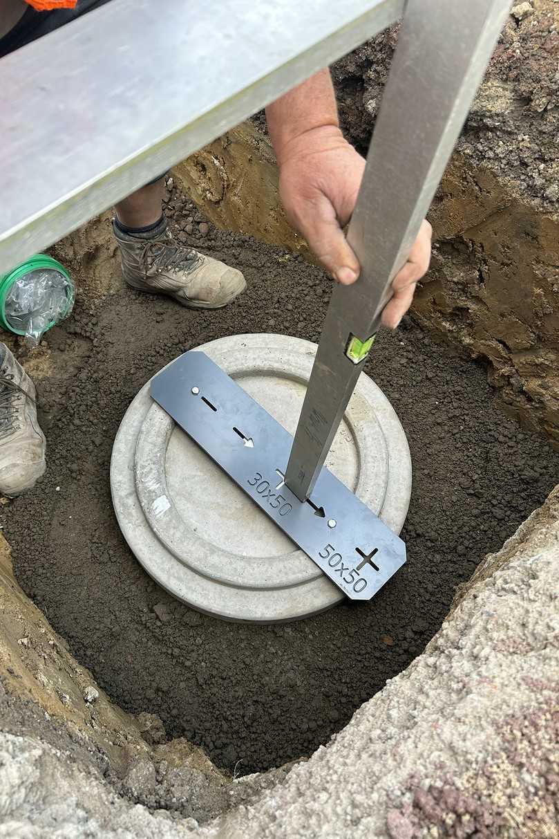 Unter den fachkundigen Augen des Funke-Anwendungstechnikers Thomas Bröer richtet ein Mitarbeiter der ausführenden Werner Pieper Straßenbau GmbH die Grundplatte mithilfe der mitgelieferten Positionsscheibe aus. | Foto: Funke Kunststoffe Unter den fachkundigen Augen des Funke-Anwendungstechnikers Thomas Bröer richtet ein Mitarbeiter der ausführenden Werner Pieper Straßenbau GmbH die Grundplatte mithilfe der mitgelieferten Positionsscheibe aus. | Foto: Funke Kunststoffe