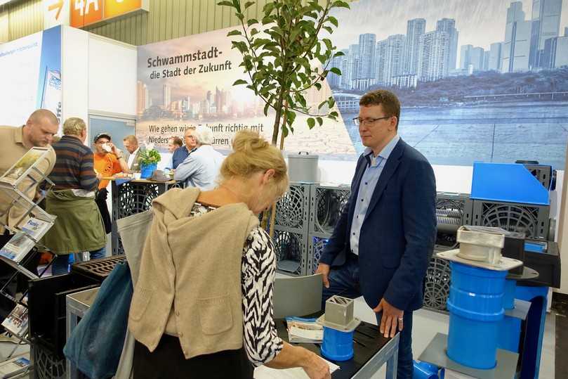Auf naturnahe Regenwasser-Bewirtschaftung in der Stadt der Zukunft vorbereitet ist die Funke Gruppe, erläutert Ansprechpartner Frank Horstmann am Messestand. | Foto: B_I/Bauer Auf naturnahe Regenwasser-Bewirtschaftung in der Stadt der Zukunft vorbereitet ist die Funke Gruppe, erläutert Ansprechpartner Frank Horstmann am Messestand. | Foto: B_I/Bauer