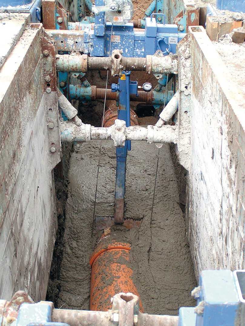Einbau in Flüssigboden, der das Rohr nahtlos umschließt. Nach der eigenständigen Verfestigung gibt es kein Nachsacken des Bodens; spätere Straßeneinbrüche sind ausgeschlossen. | Foto: RAL Gütegemeinschaft Flüssigboden e.V. Einbau in Flüssigboden, der das Rohr nahtlos umschließt. Nach der eigenständigen Verfestigung gibt es kein Nachsacken des Bodens; spätere Straßeneinbrüche sind ausgeschlossen. | Foto: RAL Gütegemeinschaft Flüssigboden e.V.