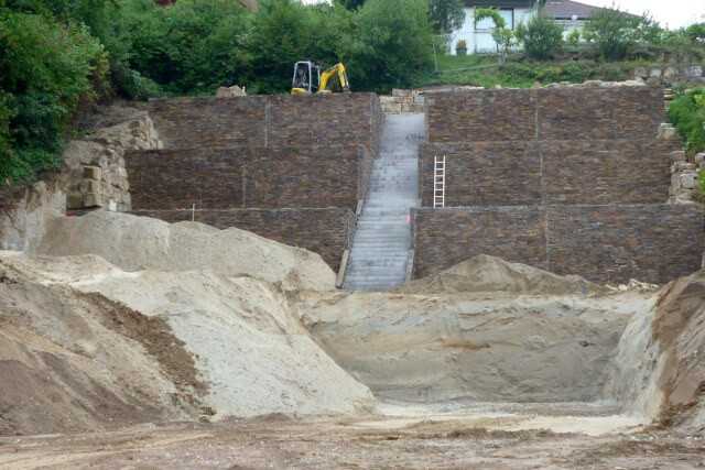 Hangstütze in drei Etagen mit Fertigteilwänden aus Stahlbeton mit Natursteinvorsatz. Hangstütze in drei Etagen mit Fertigteilwänden aus Stahlbeton mit Natursteinvorsatz.