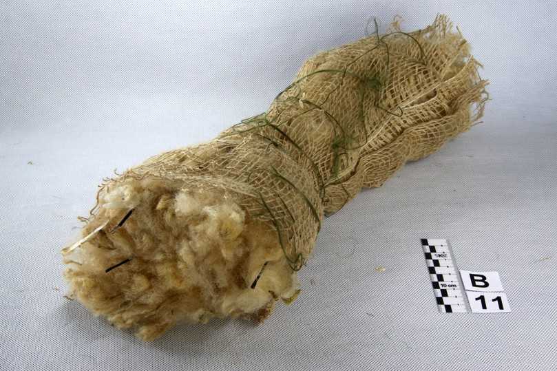 Bild 6: Naturfaserfaschine (GRO), Materialprobe mit ungewaschener Schafwolle gefüllt, mit Jutenetz umhüllt, innenlaufende Führungsseile aus Naturgarn. | Foto: SKZ-Testing GmbH Würzburg Bild 6: Naturfaserfaschine (GRO), Materialprobe mit ungewaschener Schafwolle gefüllt, mit Jutenetz umhüllt, innenlaufende Führungsseile aus Naturgarn. | Foto: SKZ-Testing GmbH Würzburg
