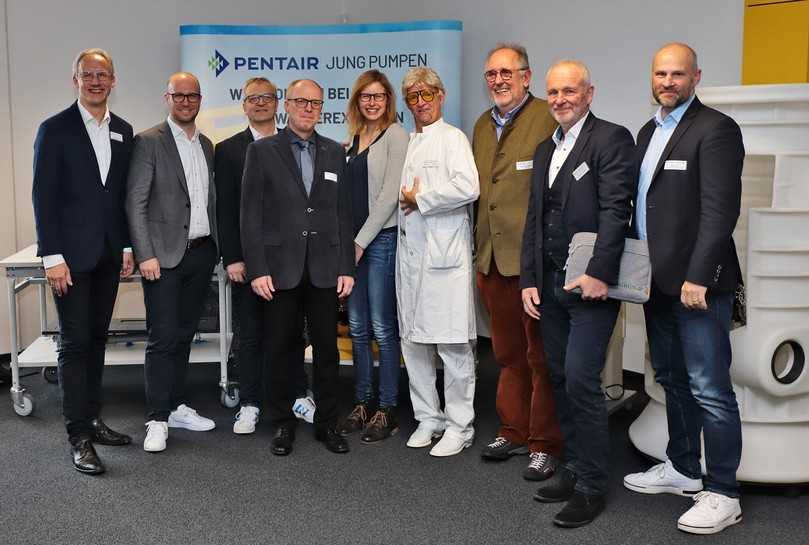 Referenten und Referentin auf dem 13. OWL-Abwassertag: (v.l.) Marco Koch (Leiter Veranstaltungswesen Jung Pumpen), Sebastian Schimmeyer (Business Development Manager, Intessence Solutions), Dipl.-Ing. (FH) Eberhard Dreisewerd (Fränkische Rohrwerke),
Prof. Dr.-Ing. Helmut Grüning (FH Münster, Fachbereich Energie-Gebäude-Umwelt), Eske Hilbrands M.Sc. (wissenschaftl. Mitarbeiterin FH Münster, Fachbereich Energie-Gebäude-Umwelt), Spezialgast „Prof. Heinz Pöter“ alias Nik Jens Lucht (Artperformance), Prof. Dr.-Ing. Franz-Peter Schmickler (FH Münster, Fachbereich Energie-Gebäude-Umwelt), Carsten Rollfing (Gebietsleitung Optigrün international), Holger Stark (Technischer Leiter Airvalve Flow Control). Es fehlt: Prof. Dr.-Ing. Jens Haubrock (FH Bielefeld, Regenerative Energiesysteme und Elektrotechnik). | Foto: Jung Pumpen Referenten und Referentin auf dem 13. OWL-Abwassertag: (v.l.) Marco Koch (Leiter Veranstaltungswesen Jung Pumpen), Sebastian Schimmeyer (Business Development Manager, Intessence Solutions), Dipl.-Ing. (FH) Eberhard Dreisewerd (Fränkische Rohrwerke),
Prof. Dr.-Ing. Helmut Grüning (FH Münster, Fachbereich Energie-Gebäude-Umwelt), Eske Hilbrands M.Sc. (wissenschaftl. Mitarbeiterin FH Münster, Fachbereich Energie-Gebäude-Umwelt), Spezialgast „Prof. Heinz Pöter“ alias Nik Jens Lucht (Artperformance), Prof. Dr.-Ing. Franz-Peter Schmickler (FH Münster, Fachbereich Energie-Gebäude-Umwelt), Carsten Rollfing (Gebietsleitung Optigrün international), Holger Stark (Technischer Leiter Airvalve Flow Control). Es fehlt: Prof. Dr.-Ing. Jens Haubrock (FH Bielefeld, Regenerative Energiesysteme und Elektrotechnik). | Foto: Jung Pumpen
