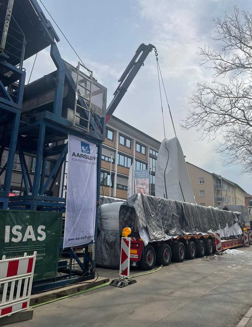 Mit Hilfe eines Teleskopkranes wird der Synthesefaserliner angehoben und für das Einstülpen in den Kanal am Inversionsturm montiert. | Foto: Aarsleff Rohrsanierung Mit Hilfe eines Teleskopkranes wird der Synthesefaserliner angehoben und für das Einstülpen in den Kanal am Inversionsturm montiert. | Foto: Aarsleff Rohrsanierung