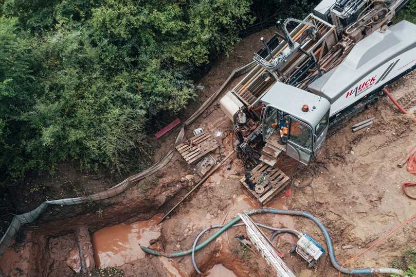Gesamtübersicht der Baustelle aus der Nähe mit Startbaugrube, dem Grundodrill 28Nplus, dem Gestängewechselmagazin sowie dem Bohrspülteich. | Foto: Tracto-Technik Gesamtübersicht der Baustelle aus der Nähe mit Startbaugrube, dem Grundodrill 28Nplus, dem Gestängewechselmagazin sowie dem Bohrspülteich. | Foto: Tracto-Technik