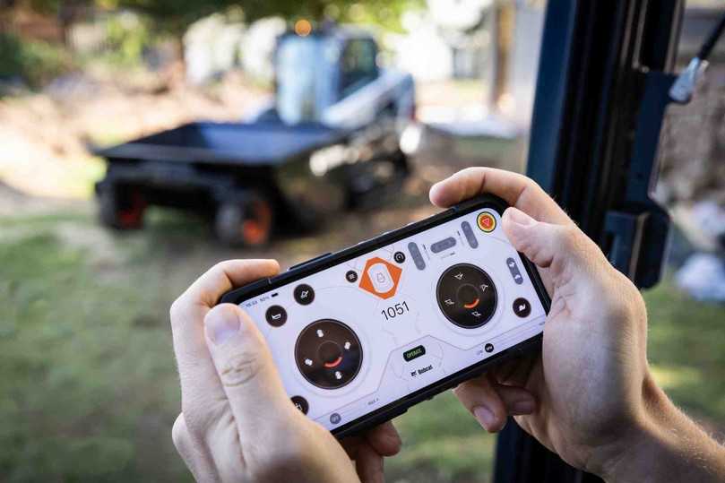 Bobcat fahren via Smartphone: Muss der Fahrer bei bestimmten Arbeiten ständig ein- und aussteigen, kann er auf die MaxControl-Fernsteuerung auf seinem Smartphone umschalten und den Lader bequem von außen bedienen. | Foto: Bobcat Bobcat fahren via Smartphone: Muss der Fahrer bei bestimmten Arbeiten ständig ein- und aussteigen, kann er auf die MaxControl-Fernsteuerung auf seinem Smartphone umschalten und den Lader bequem von außen bedienen. | Foto: Bobcat