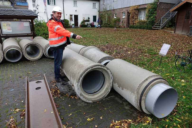 Die Fabekun-Rohre und -Schächte auf einer nahegelegenen Parkfläche zwischengelagert. Fasel-Fachberater Rüdiger Göbel weist auf das charakteristische Doppeldicht-System der Fabekun-Rohre hin. | Foto: Gebr. Fasel Betonwerk GmbH Die Fabekun-Rohre und -Schächte auf einer nahegelegenen Parkfläche zwischengelagert. Fasel-Fachberater Rüdiger Göbel weist auf das charakteristische Doppeldicht-System der Fabekun-Rohre hin. | Foto: Gebr. Fasel Betonwerk GmbH