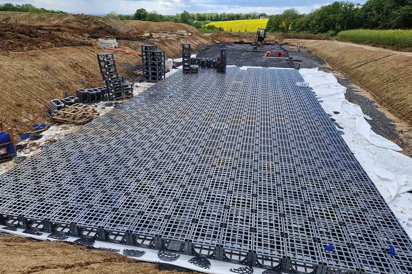 Die Kunststoffrigole hat eine geringere Breite als die eigentliche Sohlfläche der geplanten Versickerungsmulde. Aus diesem Grund werden die verbleibenden Seitenräume mit einem Rigolen-Kies 16/32 verfüllt, der ebenfalls mit Vlies ummantelt wird. Dadurch steht ein zusätzliches Rigolenvolumen zur Verfügung. | Foto: Funke Kunststoffe Die Kunststoffrigole hat eine geringere Breite als die eigentliche Sohlfläche der geplanten Versickerungsmulde. Aus diesem Grund werden die verbleibenden Seitenräume mit einem Rigolen-Kies 16/32 verfüllt, der ebenfalls mit Vlies ummantelt wird. Dadurch steht ein zusätzliches Rigolenvolumen zur Verfügung. | Foto: Funke Kunststoffe