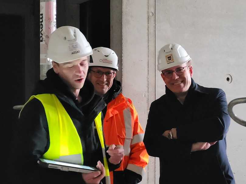Jörg Osmers (m.), Leiter Bauen im Bestand bei der Alfed Döpker Bauunternehmung, und Jörn P. Makko (r.), Hauptgeschäftsführer Bauindustrieverband Niedersachsen-Bremen, lassen sich die Funktionen des Bauroboters erklären. | Foto: B_I/bb Jörg Osmers (m.), Leiter Bauen im Bestand bei der Alfed Döpker Bauunternehmung, und Jörn P. Makko (r.), Hauptgeschäftsführer Bauindustrieverband Niedersachsen-Bremen, lassen sich die Funktionen des Bauroboters erklären. | Foto: B_I/bb