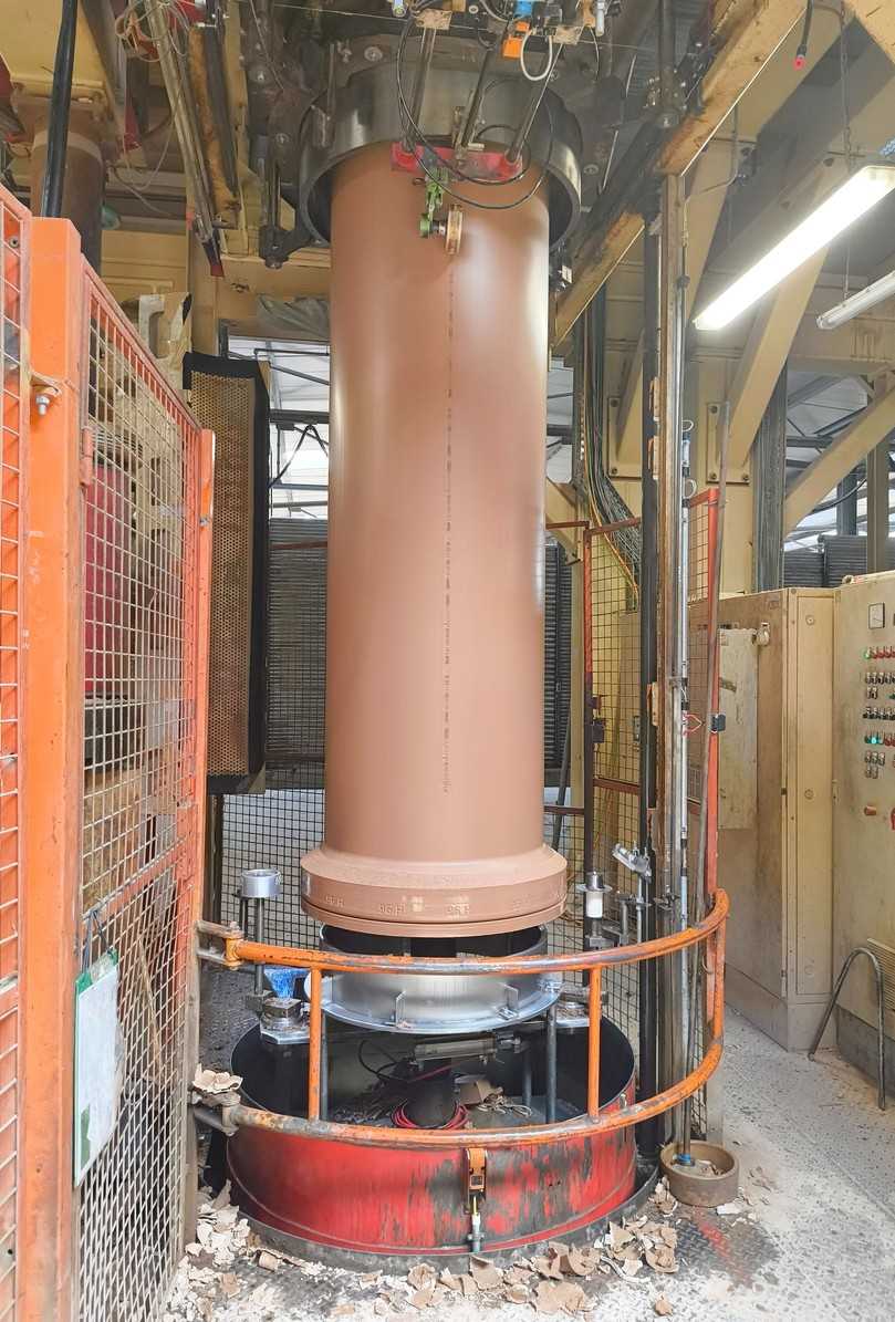 Hier wird ein Muffenrohr vertikal extrudiert. Anschließend wird es auf einen Trocknerwagen zum Weitertransport gesetzt. | Foto: B_I/Valdix Hier wird ein Muffenrohr vertikal extrudiert. Anschließend wird es auf einen Trocknerwagen zum Weitertransport gesetzt. | Foto: B_I/Valdix