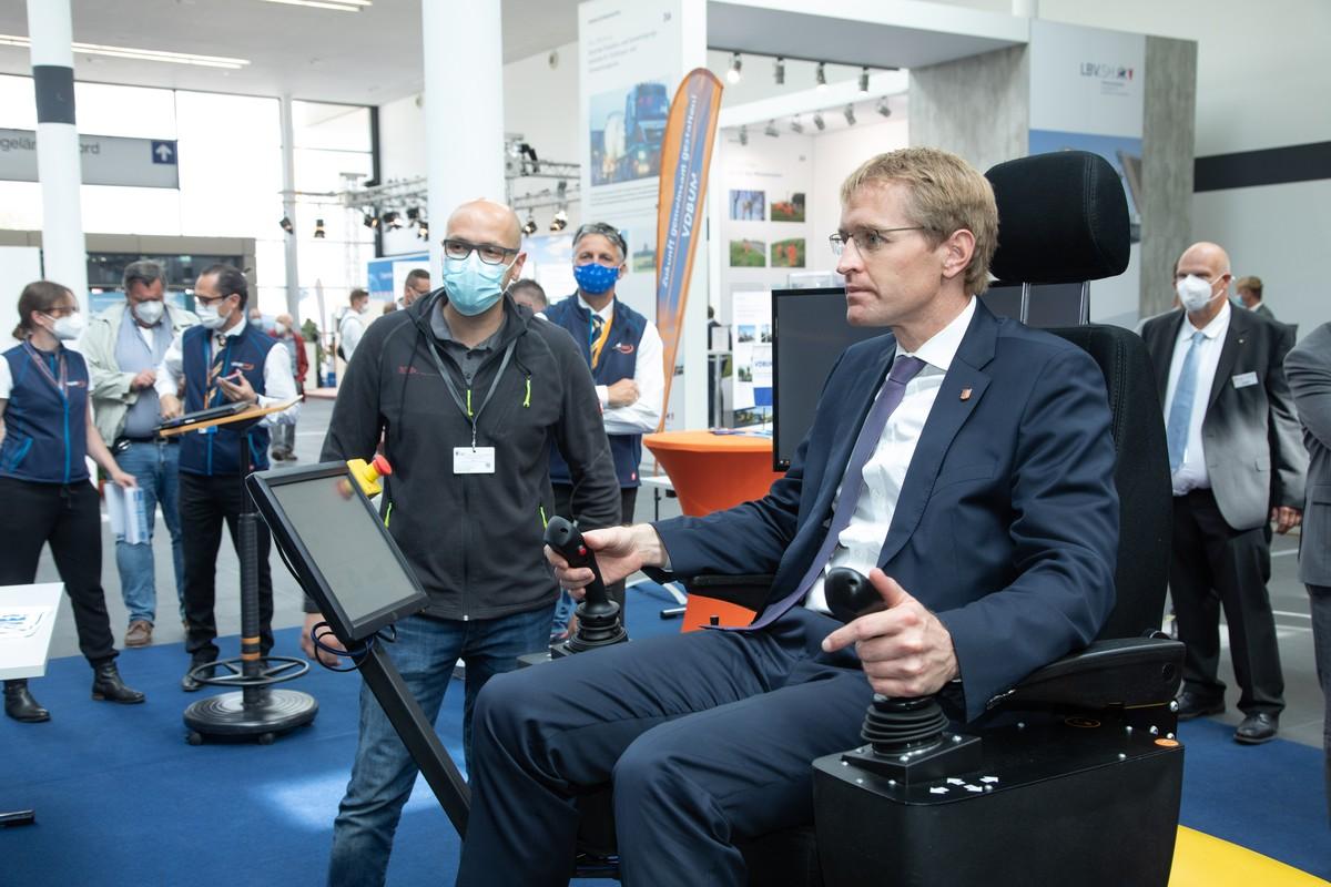 Landesvater am Steuer: Der schleswig-holsteinische Ministerpräsident Daniel Günther besuchte bei der NordBau 2021 den Stand des VDBUM und fuhr eine Übungseinheit am Baumaschinen-Simulator. | Foto: NordBau
