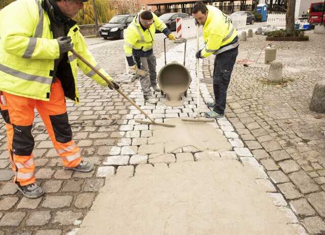 Der mineralische, schnellerhärtende und schwundneutrale Reparaturmörtel „Mortar Mix“ wird durch Zugabe von Wasser verflüssigt und in die zu bearbeitende Kopfsteinpflasterfläche eingeschwemmt. | Foto: Korodur Der mineralische, schnellerhärtende und schwundneutrale Reparaturmörtel „Mortar Mix“ wird durch Zugabe von Wasser verflüssigt und in die zu bearbeitende Kopfsteinpflasterfläche eingeschwemmt. | Foto: Korodur