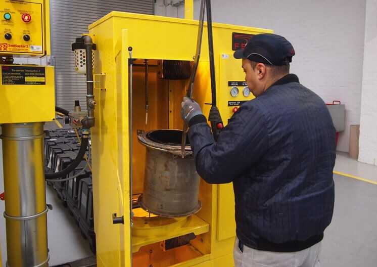 Der Komatsu-Techniker setzt das Filterelement in den Brennofen ein. Dort wird es mehrere Stunden lang bei 800 Grad „gebacken“, das heißt, sämtliche Rußreste werden zu Asche verbrannt. | Foto: Komatsu Der Komatsu-Techniker setzt das Filterelement in den Brennofen ein. Dort wird es mehrere Stunden lang bei 800 Grad „gebacken“, das heißt, sämtliche Rußreste werden zu Asche verbrannt. | Foto: Komatsu